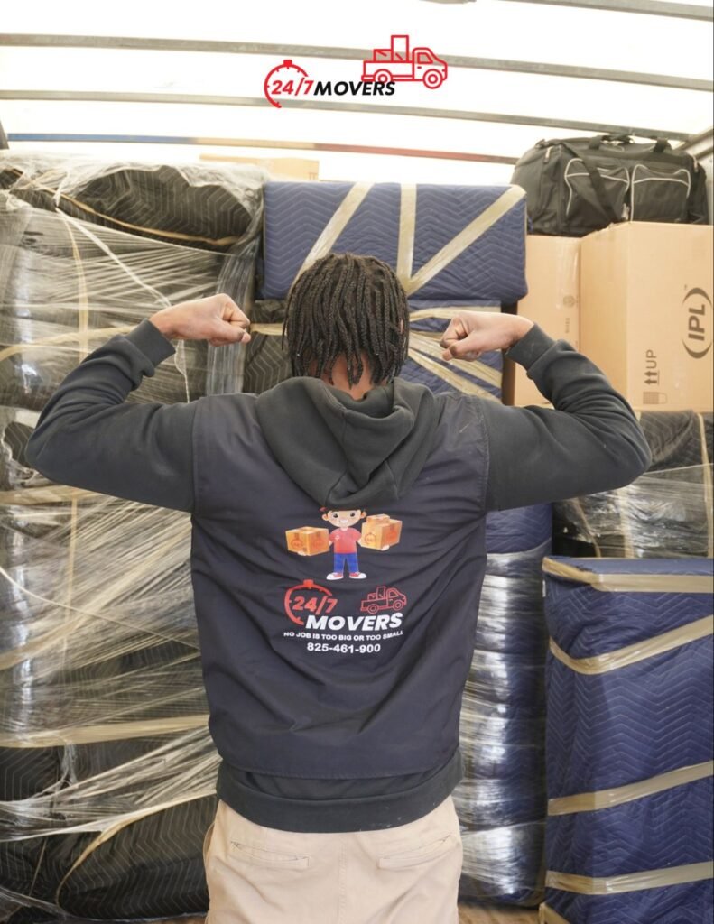 247 Movers crew member in front of a fully packed truck of wrapped furniture