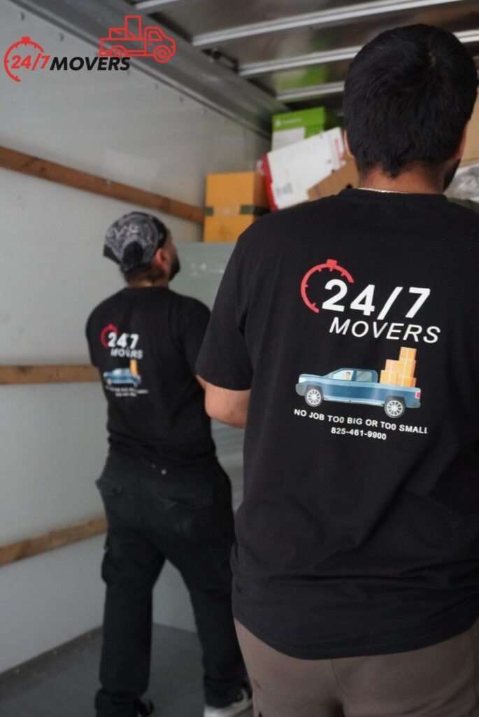Two 247 Movers crew members in company uniforms loading a truck