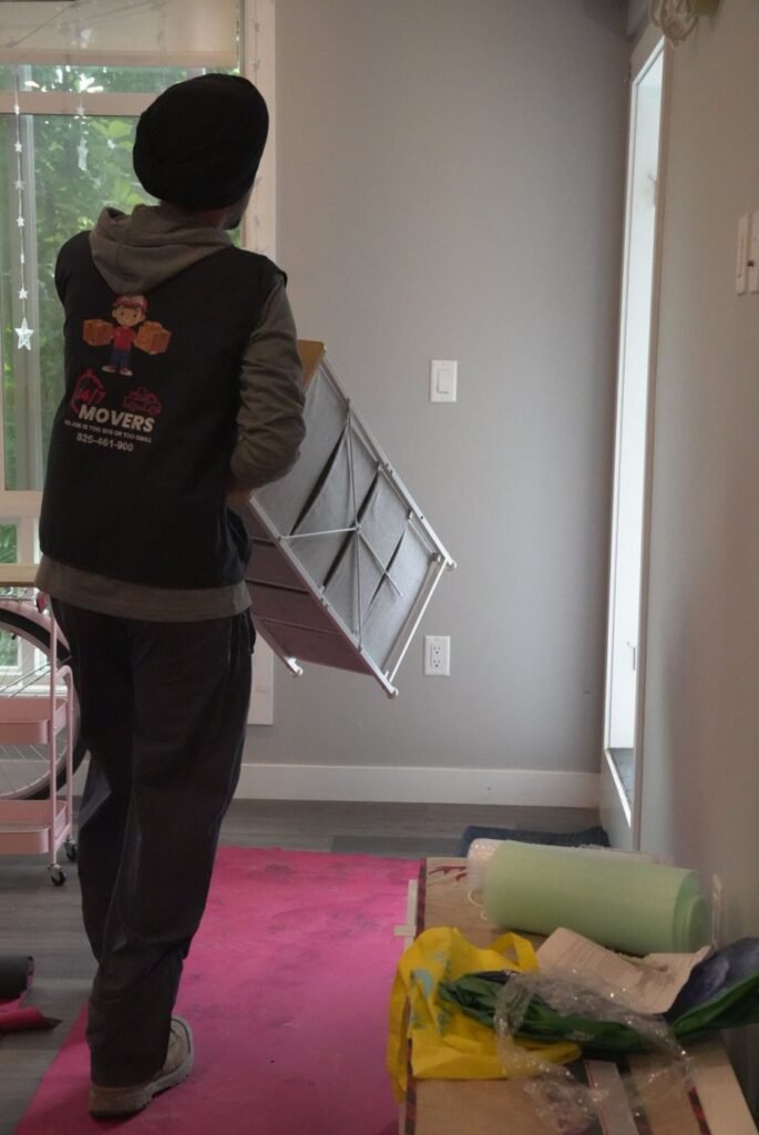 247 Movers crew member carefully handling furniture in an apartment