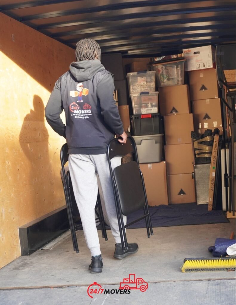 Mover loading chairs into a trailer stacked with boxes